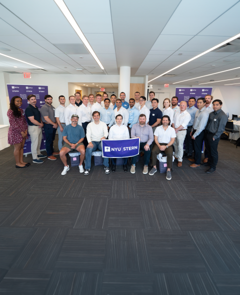 Military Veteran alumni hold an NYU Stern banner for a group photo