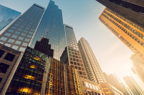 view of highrise buildings from street-level, with golden glow reflecting on buildings