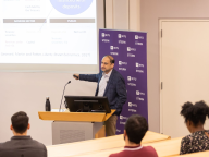 A photo of Professor Viral Acharya speaking behind a podium