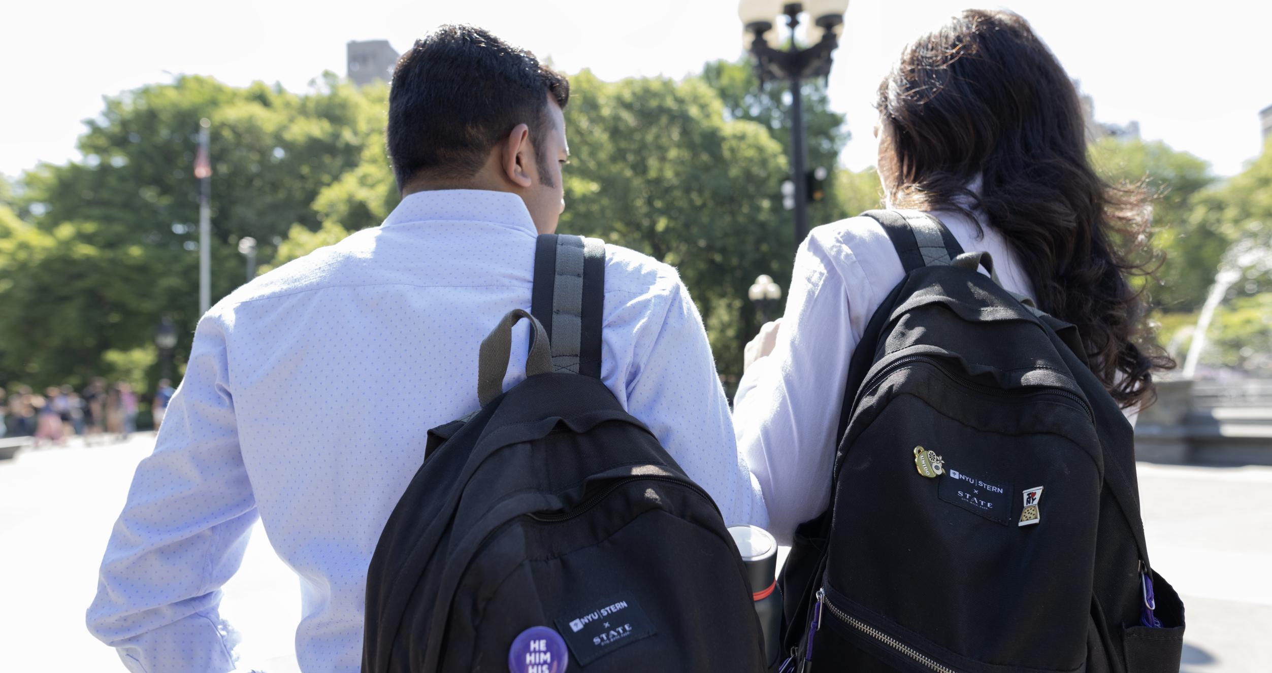 Two students wear their Stern backpacks in Washington Square Park