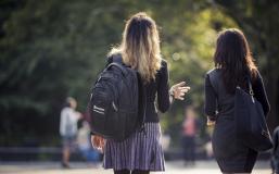 Two students walking through Washington Square Park