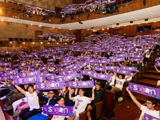 New undergraduate students holding up purple We Are Stern banners during orientation 