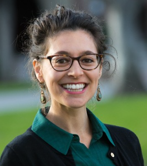 A picture of Allyson Dhindsa - A brown haired white woman, smiling at the camera in a collared shirt