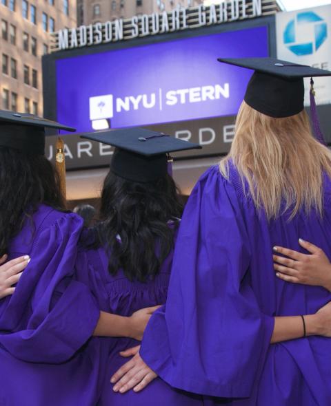 Backs of students in caps and gowns outside of Madison Square Garden