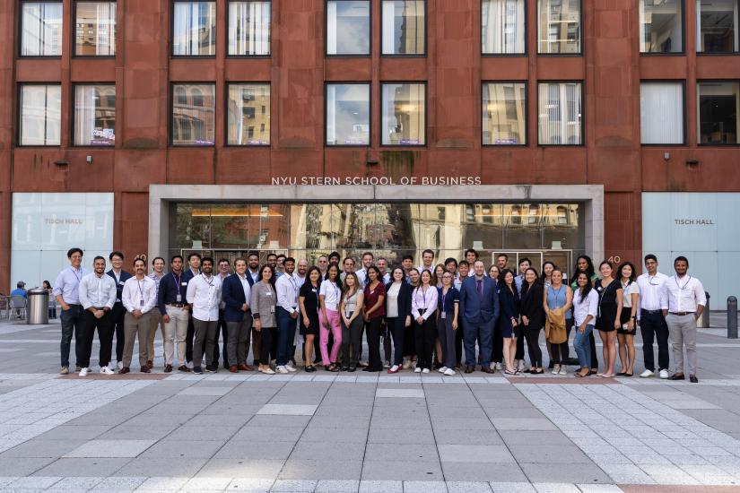 A group of MSQM students stand in front of Tisch Hall.